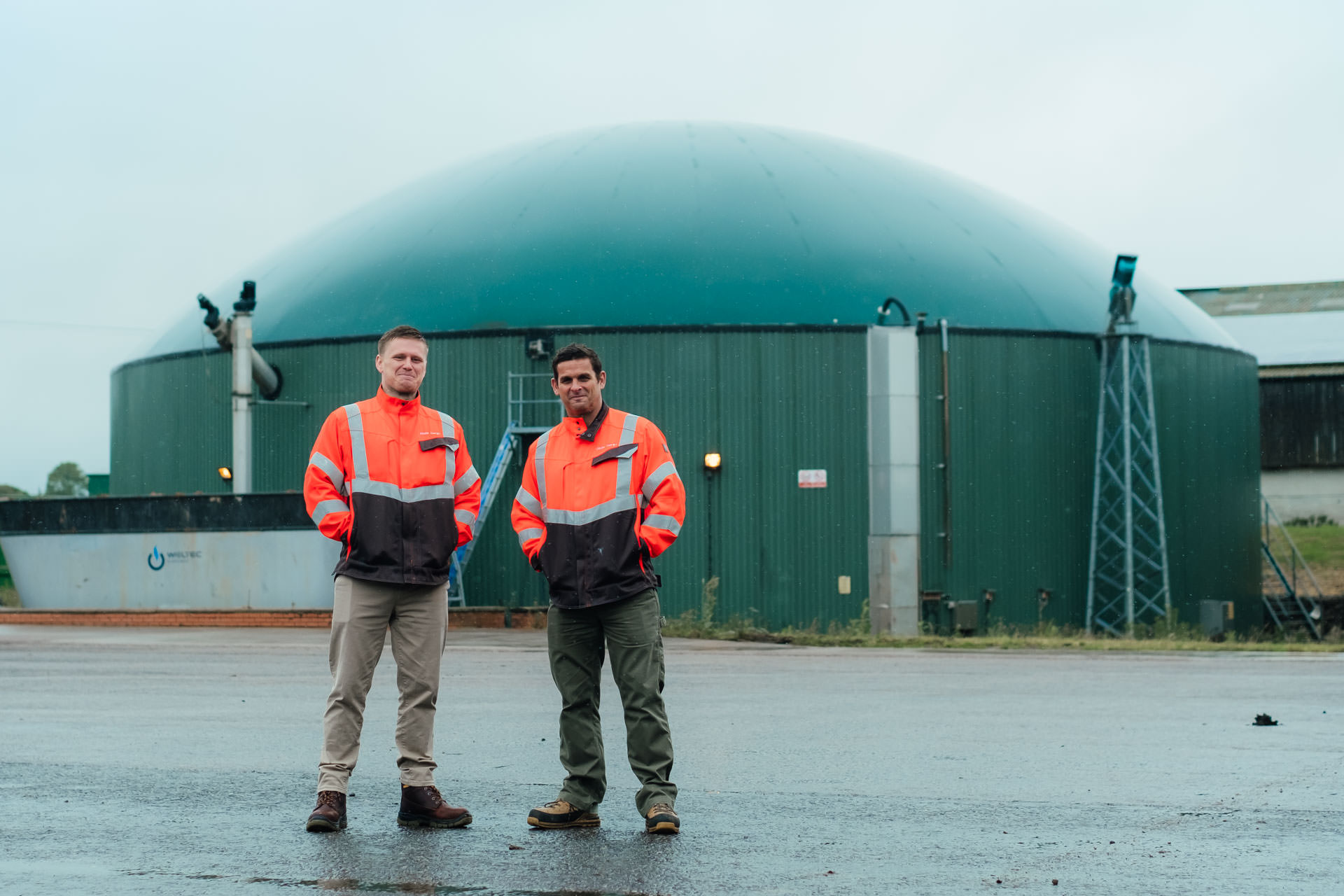 ONM-energy-anaerobic digestion consultants Ricky Malin and Kyrone Dodd stand in front of digestion tank 